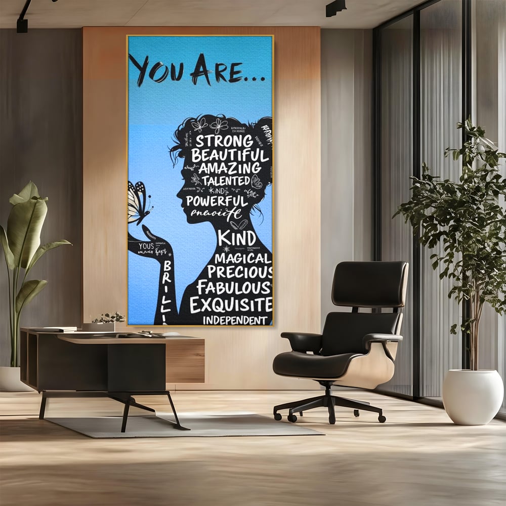 Tablou canvas cu tablou motivational cu portret de femeie si cuvinte, in rama de aluminiu auriu, pe perete intr-un birou